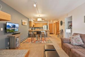 a living room with a couch and a kitchen at Lagoon Royal Townhome: Mountain Views Meet Modern Comforts in Frisco