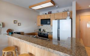 a kitchen with a refrigerator and a counter top at River Mountain Lodge Peaks Trail Condo: Ski-In, Downtown Breck in Breckenridge