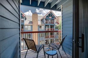 a balcony with two chairs and a glass table at River Mountain Lodge Peaks Trail Condo: Ski-In, Downtown Breck in Breckenridge