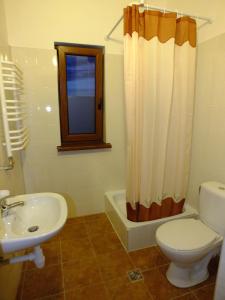 ein Badezimmer mit Toilette und Waschbecken in der Unterkunft Pokoje Gościnne VEIKSME in Bestwina + 7 Fotos