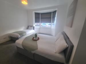 a bedroom with two beds and a window at 2 bed central apartments in South Shields