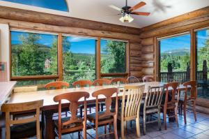 - une salle à manger avec une table, des chaises et de grandes fenêtres dans l'établissement Swan River Lodge Home: Spacious, Hot Tub, à Gold Hill