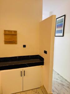 une cuisine avec des murs jaunes et un comptoir noir dans l'établissement Maison N 20, à Oulad Akkou