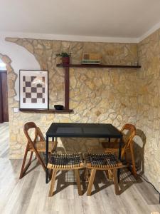 een tafel en stoelen voor een stenen muur bij Casa da Ti'nês in Bombarral +8 foto's