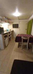 eine kleine Küche mit einem Tisch, einem Tisch und Stühlen in der Unterkunft BackPakersBasic in Tigre
