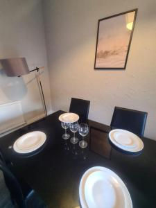 a dining room table with plates and wine glasses on it at 2 bed central apartments in South Shields