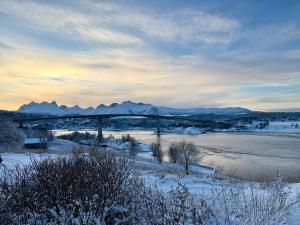 a bridge over a river with snow on the ground at Saltstraumen Hotel og Fjordhytter in Bodø