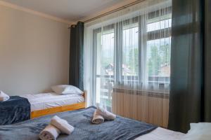 a bedroom with two beds and a large window at Ski Lodge przy Gondoli - Szczyrk in Szczyrk