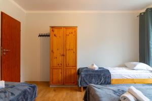 a bedroom with two beds and a wooden cabinet at Ski Lodge przy Gondoli - Szczyrk in Szczyrk