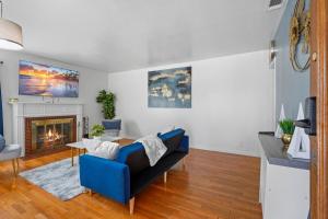 un salon avec un canapé bleu et une cheminée dans l'établissement Hot Tub - Pool - FirePit - GameRoom - Sleeps 12!, à Riverside