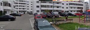 a parking lot with cars parked in front of a building at Apartament Royal in Şelimbăr