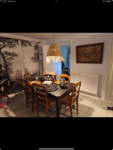 einen Esstisch mit Stühlen und einem Kronleuchter in der Unterkunft The Cottage at 7 in Sainte-Foy-la-Grande