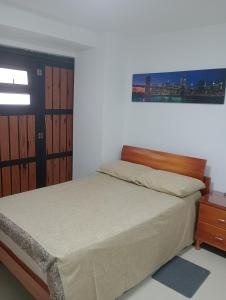 une chambre avec un lit avec une tête de lit en bois dans l'établissement "La casa de mi tia" Agradable, Acogedor, Tranquilo, à Envigado