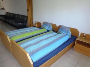 a large bed with blue sheets and blue pillows at Rehalp Westen in Bischofszell