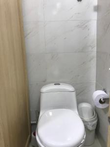 une salle de bain avec des toilettes blanches et un rouleau de papier toilette dans l'établissement "La casa de mi tia" Agradable, Acogedor, Tranquilo, à Envigado