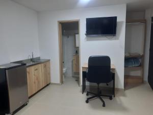 Cette chambre comprend un bureau avec une chaise et une télévision. dans l'établissement "La casa de mi tia" Agradable, Acogedor, Tranquilo, à Envigado 5 autres photos