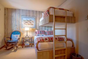 une chambre avec un lit superposé et une chaise dans l'établissement Andora Alpine Retreat - 2BD in downtown Ketchum, à Ketchum