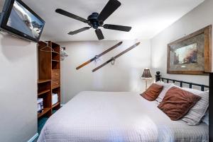 布雷肯里奇Tannhauser II Condo: Downtown Breck的一间卧室配有吊扇和一张床