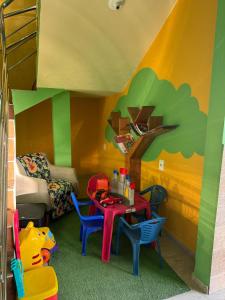 a play room with a table and chairs and a bunk bed at Pousada Paraíso Tropical in Penha