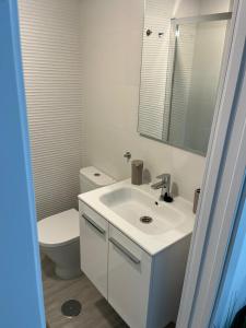 Un baño con lavabo blanco y inodoro. en Olas del Sur Apartment, en La Cala de Mijas 5 fotos más