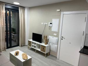 a living room with a television and a door at Olas del Sur Apartment in La Cala de Mijas