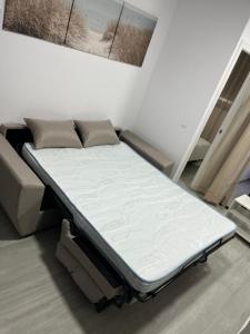 1 cama en una habitación junto a un sofá en Olas del Sur Apartment, en La Cala de Mijas