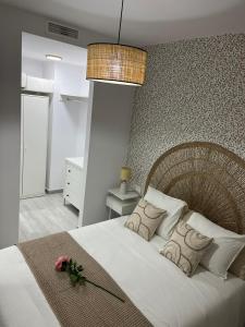 Un dormitorio con una gran cama blanca con una flor encima. en Olas del Sur Apartment, en La Cala de Mijas