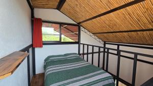 a small room with a bed and a window at Casa del Árbol Xochimilco in Oaxaca City