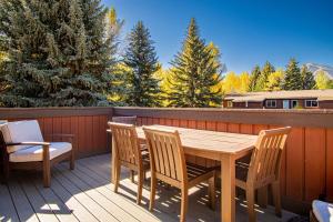 a wooden table and chairs on a deck at Atelier Alpine - Modern 2BD Condo w/Baldy Views in Sun Valley