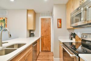 Una cocina con gabinetes de madera y un fregadero. en Lake Forest Lakeside Condo: Mountain, Lake Views, en Summit Medical Center Heliport