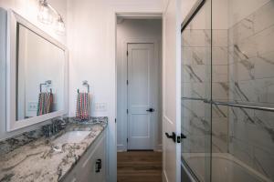 ein Badezimmer mit Waschbecken, Dusche und Spiegel in der Unterkunft Glory Be in Edisto Island + 74 Fotos