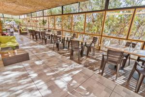 a restaurant with tables and chairs and windows at Geotel Calama in Calama