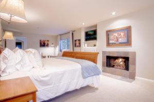 - une chambre avec un lit blanc et une cheminée dans l'établissement Trail Creek Treasure - Luxury 3BD nr SV Ski Lifts, à Ketchum
