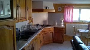 eine Küche mit Holzschränken, Spüle und Herd in der Unterkunft Wohnung Du Coucou In Lichtenberg in Lichtenberg