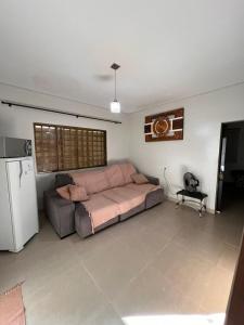 un grand salon avec un lit et un réfrigérateur dans l'établissement 2 Quartos, sala e 1 banheiro próximos à Universidade Federal de Rondonópolis- UFR, à Rondonópolis