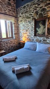 a bedroom with a large bed with two towels on it at Αρχοντικό Πανόραμα in Melívoia