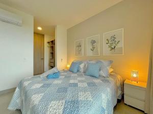 ein Schlafzimmer mit einem großen Bett mit blauen Kissen in der Unterkunft Apartamento de lujo en Santa Marta con Vista al Mar in Santa Marta