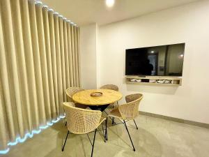 einen Holztisch und Stühle in einem Zimmer mit Vorhängen in der Unterkunft Apartamento de lujo en Santa Marta con Vista al Mar in Santa Marta