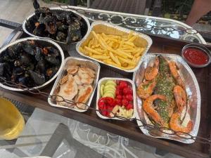 a table with four trays of different types of food at Villa Ivan in Risan