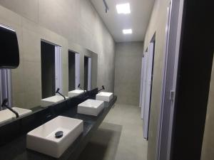 a bathroom with three sinks and two mirrors at O Ogro in Brasilia +20 photos
