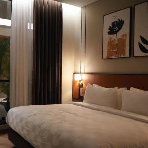 ein Schlafzimmer mit großem Bett und Fenster in der Unterkunft Cordela Suites Cianjur in Cianjur