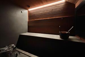 a bathroom with a bowl on a counter with a light at Levi Nordic Star Igloos in Kittilä +11 photos