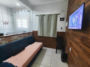 a living room with a couch and a tv in it at Aconchego Terramar in Cabo Frio