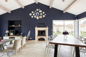 a dining room with blue walls and a table and chairs at La Tour Maréchal - Gîte d'exception avec piscine in LʼHerbergement +53 photos