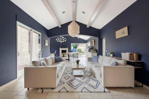 a living room with blue walls and white couches at La Tour Maréchal - Gîte d'exception avec piscine in LʼHerbergement