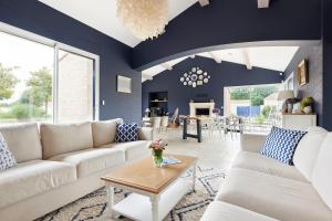 a living room with blue walls and white furniture at La Tour Maréchal - Gîte d'exception avec piscine in LʼHerbergement