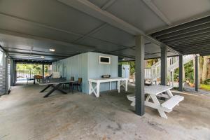 eine große Garage mit einem Tisch und Bänken darin in der Unterkunft Ocean Shade in Edisto Beach