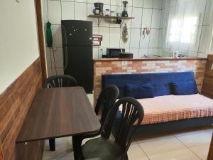 a kitchen with a table and chairs and a bed at Aconchego Terramar in Cabo Frio