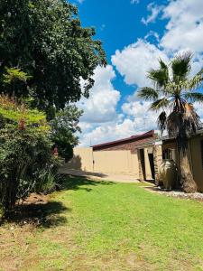 a yard with a building and a palm tree at Suider home stay in Johannesburg