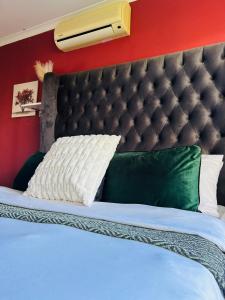 a bed with a black headboard and green pillows at Suider home stay in Johannesburg +31 photos